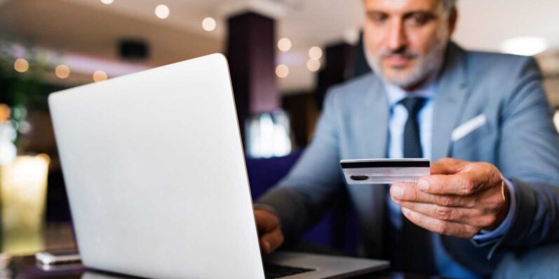 empresario-com-laptop-segurando-cartão-de-crédito